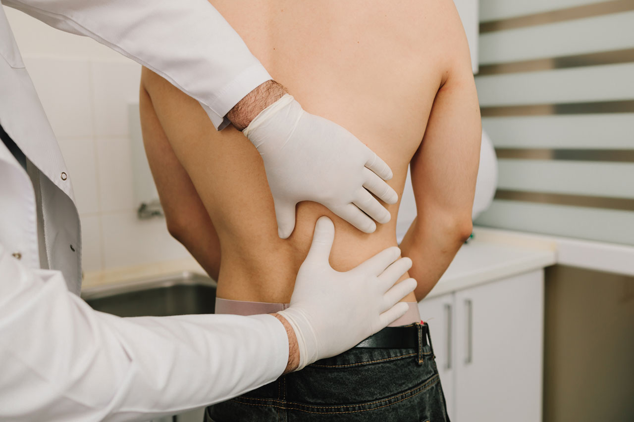 Médico valorando a un paciente con dolor de espalda