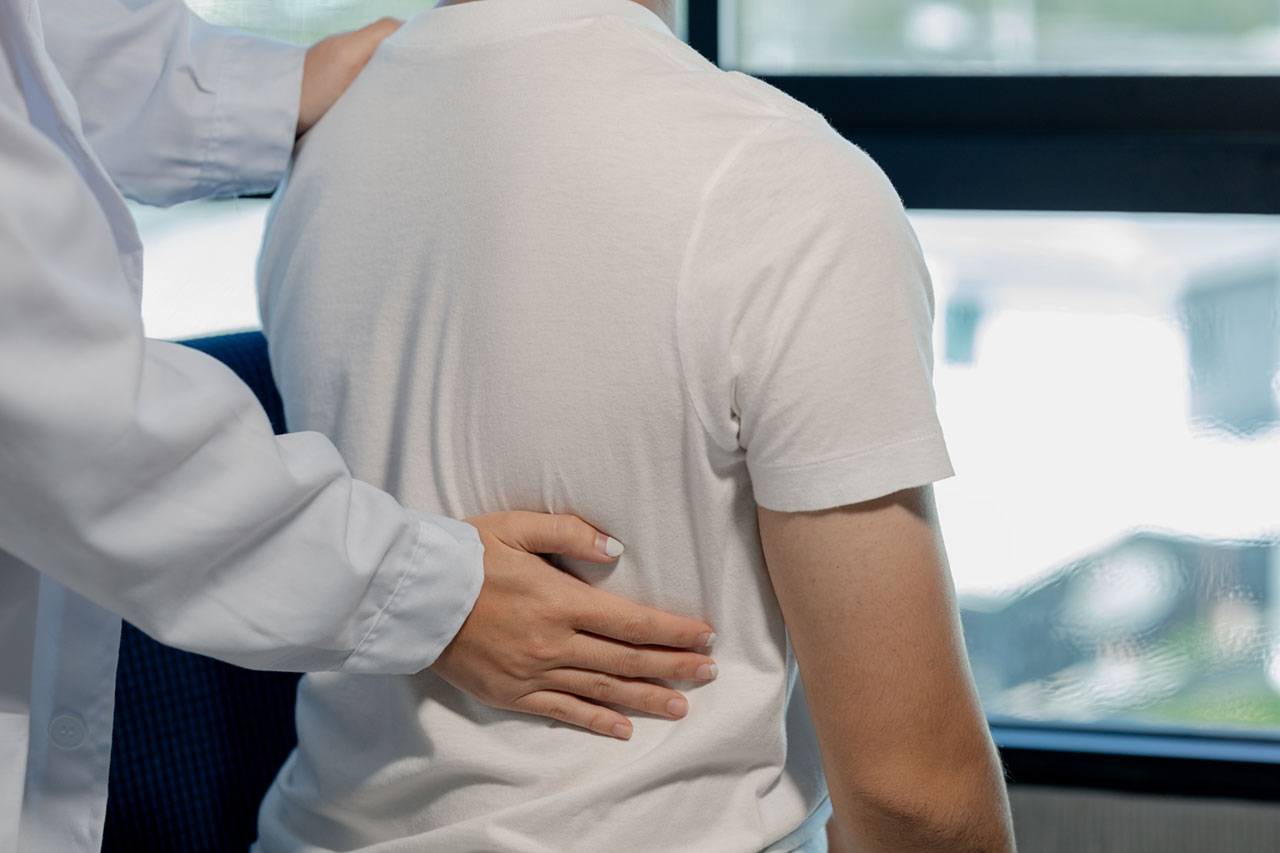 Médico valorando a un paciente con dolor de espalda