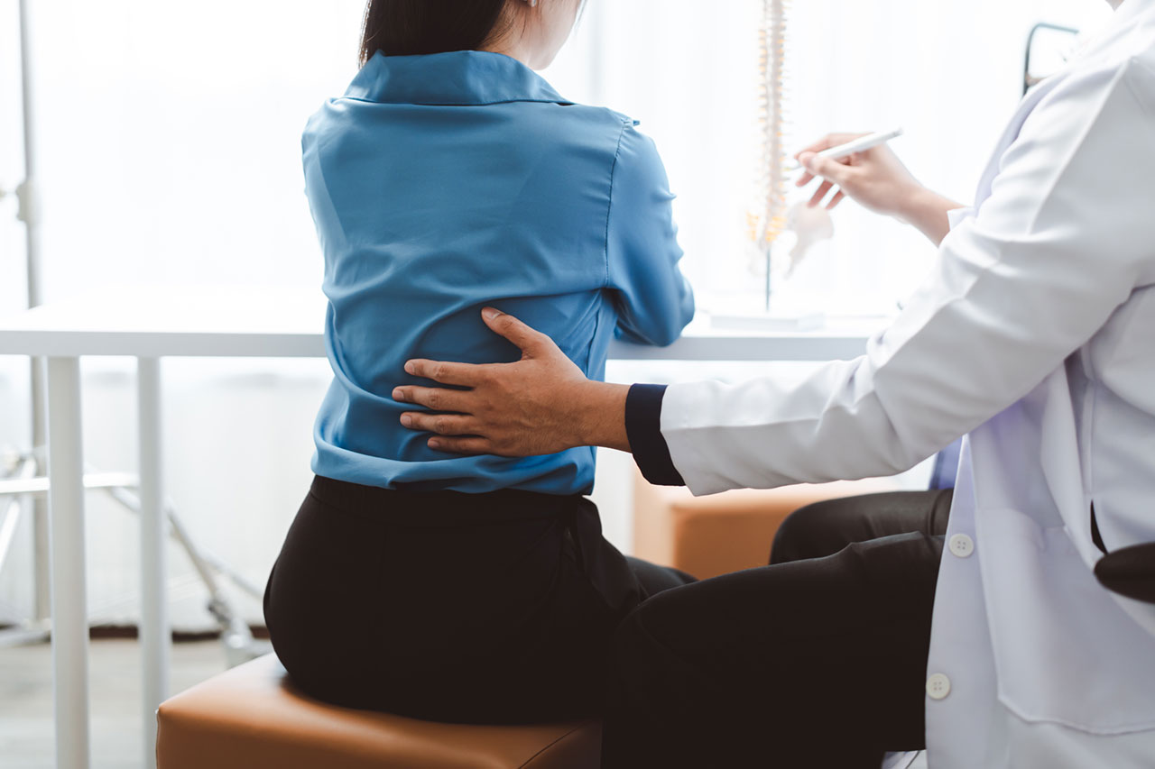 Médico valorando a un paciente con dolor de espalda